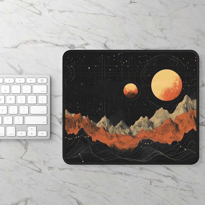 K&ouml;nnte beinhalten: Eine schwarze Mauspad mit einem grafischen Design eines sternenklaren Nachthimmels mit Bergen und zwei orangefarbenen Planeten.