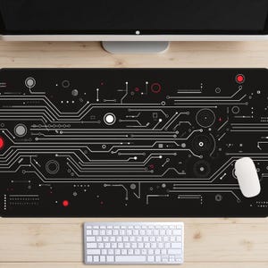 May include: Black rectangular computer mouse mat featuring a white circuit board design. The design includes white, red, and grey lines, circles, and dots. A white mouse and keyboard are visible.