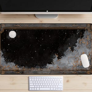May include: A rectangular desk mat featuring a night sky design with a full moon, stars, and clouds. The color palette includes black, gray, and gold accents. A white computer mouse and keyboard are visible.