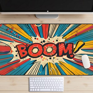 May include: A colorful comic book style mousepad with a red "BOOM!" graphic on a blue, yellow, and red background.