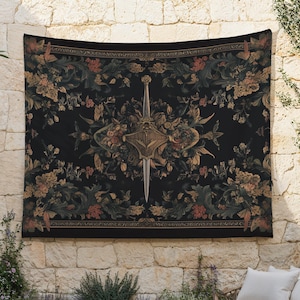 May include: A black tapestry with a floral and sword design. The tapestry features a central sword and shield motif surrounded by flowers in shades of gold, peach, and green. The background is a dark, rich black.