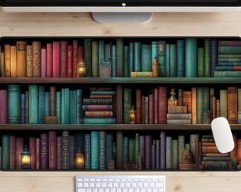 May include: A desk mat with a detailed illustration of a bookshelf filled with colourful books. The design includes various book sizes and colours, with decorative lanterns. A white keyboard and mouse are visible on a light wood-grain surface, with a computer monitor above.