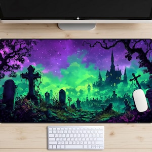 Puede incluir: Un tapete de ratón con degradado verde y morado con una escena de Halloween espeluznante. La escena presenta una silueta de un castillo encantado con un cementerio en primer plano. El tapete de ratón es perfecto para jugadores y cualquier persona que ame Halloween.