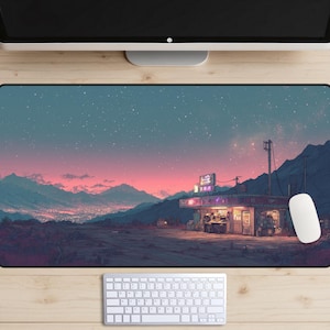 May include: A rectangular mouse pad featuring a digital art landscape with a gas station under a starry sky. The color palette includes pink, blue, and purple hues. A white mouse and keyboard are visible.