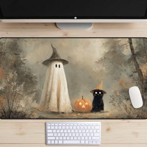 May include: A Halloween-themed mousepad featuring a whimsical illustration. A ghost and a black cat, both wearing witch hats, stand beside a carved pumpkin. The background depicts a misty forest scene, with a keyboard and mouse visible.