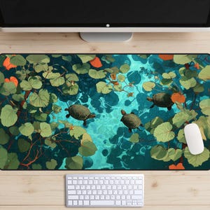 May include: A rectangular mouse pad featuring an artistic depiction of turtles swimming in a pond. The design includes green lily pads, orange accents, and a turquoise water background. A white mouse and keyboard are visible.