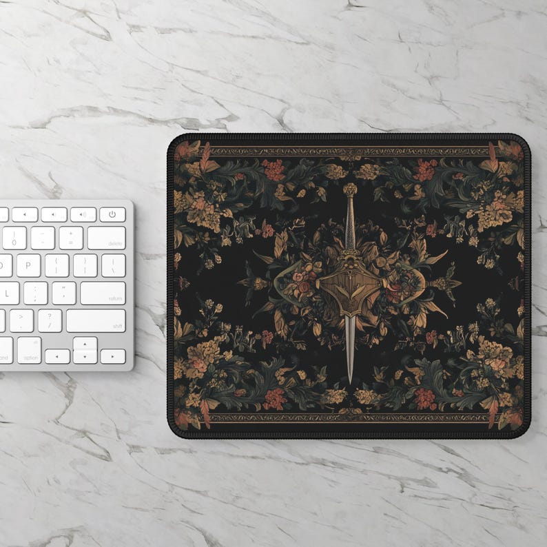 May include: A black mouse pad with a floral pattern and a sword in the center. The sword is surrounded by a shield and flowers. The background is black with gold accents.