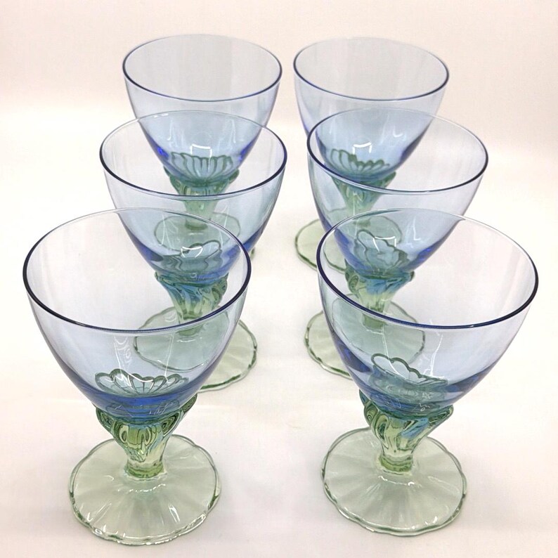 K&ouml;nnte beinhalten: Sechs Vintage-Weingl&auml;ser mit blauem Stiel. Die Schalen sind hellblau, mit einem dekorativen blau-gr&uuml;nen Stiel und einem gr&uuml;nen Fu&szlig;. Die Gl&auml;ser sind in zwei Dreierreihen angeordnet.