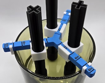 May include: A 3D-printed tool with black vertical posts and blue and white measuring arms. The arms are labeled with measurements in inches. The tool is designed to be used inside a clear glass container.