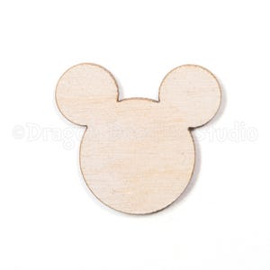Peut inclure: Une forme de tête de Mickey Mouse en bois, composée d'une grande tête circulaire et de deux petites oreilles circulaires. Le bois est de couleur brun clair naturel et a une surface lisse. Idéal pour le bricolage.