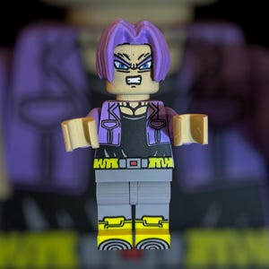 May include: A Lego-style figure of a character with purple hair, wearing a purple jacket over a black shirt, gray pants, and yellow boots. The figure has an angry expression and is a collectible item.
