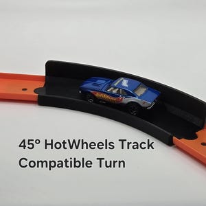 May include: A black plastic 45 degree turn track piece for Hot Wheels cars. The track piece is compatible with standard Hot Wheels track.