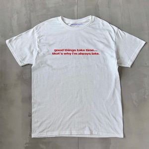 Peut inclure: T-shirt blanc avec un texte rouge qui dit "good things take time... that's why I'm always late."