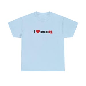 Op de afbeelding: Lichtblauw T-shirt met de tekst "i &hearts; men" gedrukt in zwart met een rood hart.