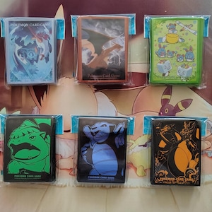 May include: Ten packs of trading card sleeves arranged in two rows, each featuring distinct character illustrations and the text Pokémon Card Game. The designs include various colorful creatures, dynamic action scenes, and stylized silhouettes on black, green, blue, and orange backgrounds.