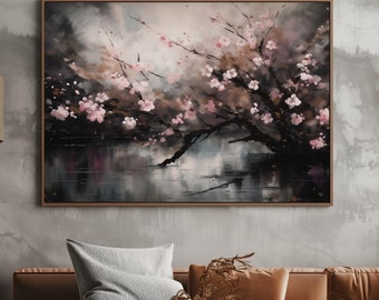 May include: A painting of a cherry blossom tree with pink flowers in bloom, reflected in a still body of water. The painting is framed in a dark wood frame and hangs on a gray wall above a brown leather couch.
