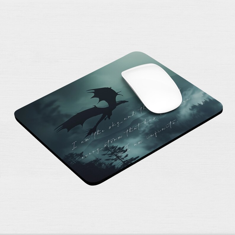 May include: A dark green mousepad with a silhouette of a dragon flying through a stormy sky. The text "I am after the sky and the every-storm that has been. I am infinite." is printed on the mousepad.