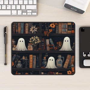 May include: A black and white illustration of a bookshelf with a dark background. The bookshelf is filled with books and has three white ghosts on the shelves. The ghosts are floating in front of the books.