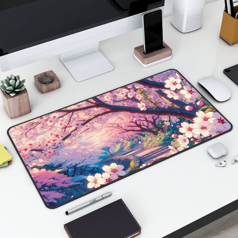 May include: A black mouse pad with a colorful design of pink cherry blossoms and a path leading to a Japanese-style building. The design is set against a purple and blue sky.