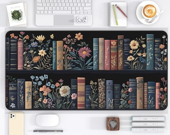 May include: A black and white desk mat with a design of a bookshelf filled with colorful books and flowers. The books are arranged in rows on the shelves, and the flowers are growing out of the books. The design is a whimsical and charming way to add a touch of nature to your workspace.