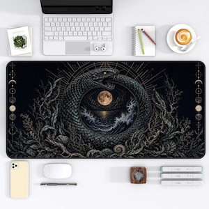 Pode incluir: Um tapete de secretária retangular com uma ilustração escura e detalhada de uma serpente ouroboros a rodear uma lua cheia sobre um oceano turbulento. O design inclui algas, conchas e fases lunares ao longo das margens laterais.