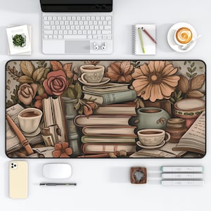 Puede incluir: Un ratón de ordenador marrón y beige con un diseño floral y una pila de libros. El diseño también incluye tazas de café y té, y un bolígrafo y un tintero.
