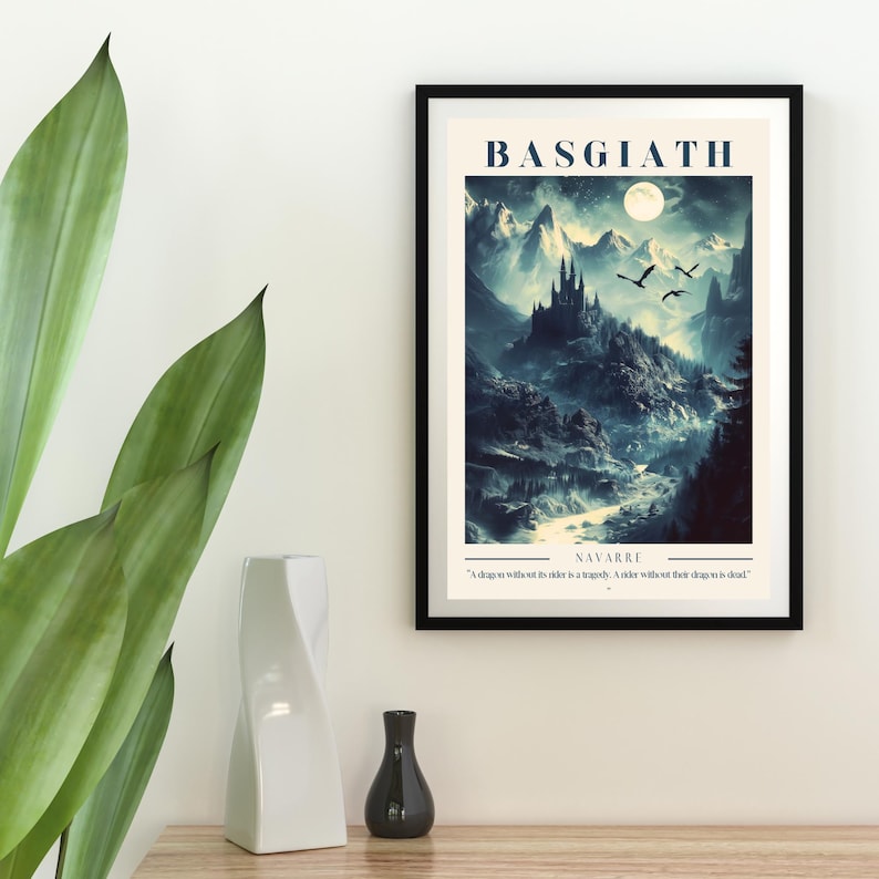 May include: A framed print with a fantasy landscape featuring a castle, mountains, and a river. The print is titled "Basgiath" and includes the quote "A dragon without its rider is a tragedy. A rider without their dragon is dead."