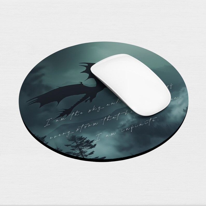 May include: A round mouse pad with a dark green and black design featuring a silhouette of a dragon flying through a stormy sky. The text "I am the sky and every storm that breaks I am infinite." is printed on the mouse pad.