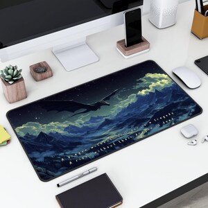 May include: A black and blue gaming mouse pad with a dragon flying over a mountain range. The text on the mouse pad reads "A dragon without its rider is a tragedy. A rider without their dragon is dead."