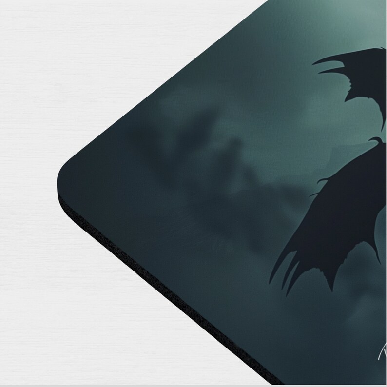 May include: A dark blue and black mousepad with a silhouette of a dragon flying through a stormy sky.