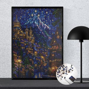 May include: A rectangular framed wall art piece featuring a stained glass style illustration of a mountain village at night under a starry sky, accompanied by a circular container filled with loose puzzle pieces of the same image.