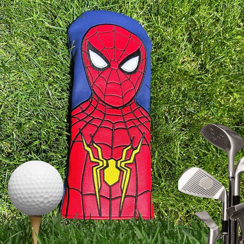 Puede incluir: Una funda para la cabeza de un palo de golf de color rojo y azul con un dise&ntilde;o de Spiderman. La funda presenta una imagen detallada de la cara de Spiderman y un dise&ntilde;o de telara&ntilde;a.