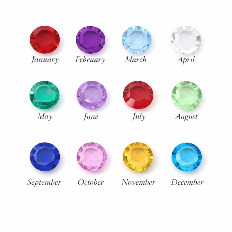 May include: A collection of twelve colorful gemstones, each representing a month of the year. The gemstones are arranged in three rows of four, with the months January through December labeled below each stone. The gemstones are red, purple, light blue, clear, green, light purple, red, light green, blue, pink, yellow, and turquoise.