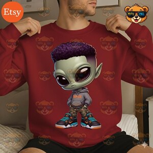 May include: A maroon sweatshirt featuring a cartoon alien character with a purple afro, wearing a gray hoodie, camouflage pants, and sneakers. The sweatshirt has a repeating pattern of cartoon bears wearing sunglasses.