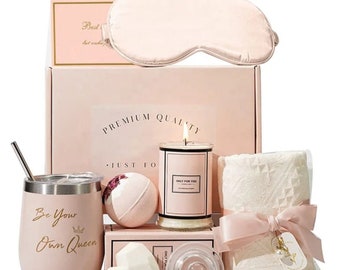 May include: A pink gift box containing a selection of self-care items, such as a candle, bath bomb, eye mask, tumbler, and a small towel. The box features the text "Premium Quality" and "Just For You".
