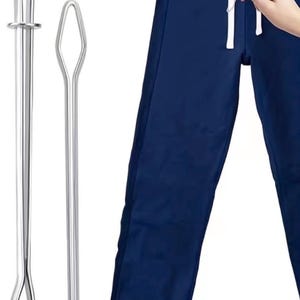 Può includere: Un paio di pantaloni della tuta blu navy con coulisse bianca e due strumenti in metallo argentato. Gli strumenti hanno forme diverse, uno con un anello e l'altro con un'estremità piatta.