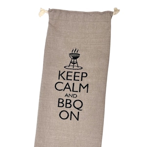 May include: A beige linen drawstring bag with a black embroidered design that says "Keep Calm and BBQ On" with a grill graphic above the text.