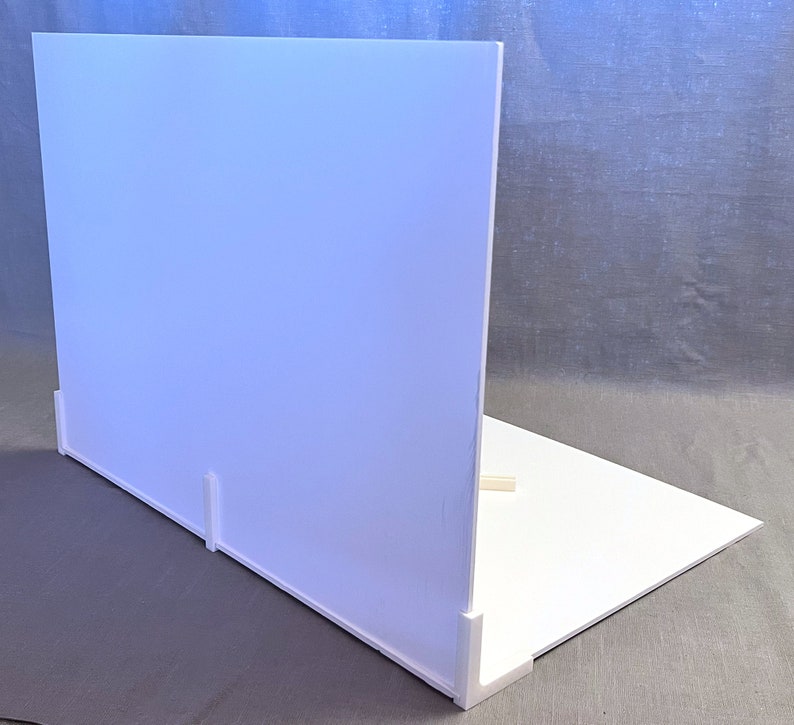 May include: White backdrop for product photography, made of foam board. It features a white background and a white base with a slight angle for a more dynamic look.