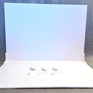 May include: White backdrop with three white corner pieces on a white surface.