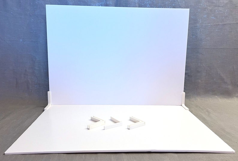 May include: White backdrop with three white corner pieces on a white surface.