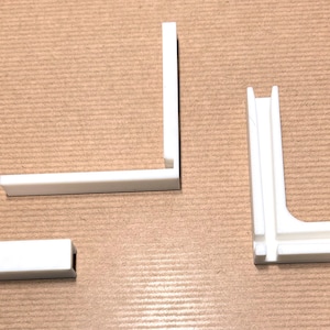 May include: Three white plastic corner brackets, two with a simple L-shape and one with a more complex design featuring a double-layered corner.
