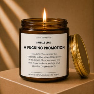 Peut inclure: Une bougie en cire de soja allumée dans un pot en verre ambré avec un couvercle doré. L'étiquette blanche indique : CANDLESARTSHOP, SMELLS LIKE A FUCKING PROMOTION, You did it. You climbed the corporate ladder without losing your mind. 250 G.