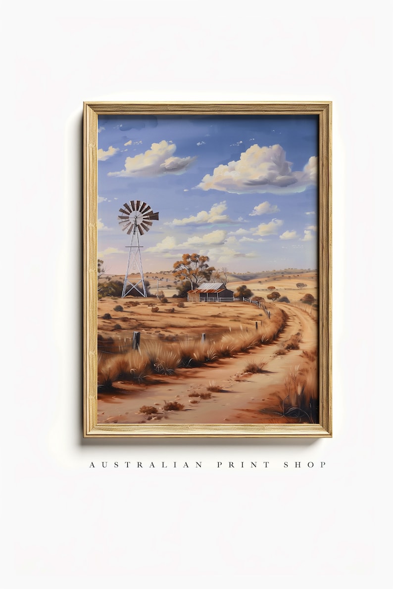 May include: A framed painting of a rural Australian landscape with a windmill, a small wooden shack, and a dirt road leading into the distance. The sky is blue with white clouds.