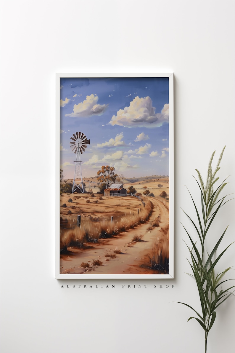 May include: A painting of a rural Australian landscape with a windmill, a small wooden building, and a dirt road leading into the distance. The sky is blue with white clouds. The scene is painted in a realistic style.