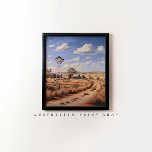 May include: A framed painting of a rural Australian landscape with a windmill, a farmhouse, and a dirt road leading into the distance. The sky is blue with white clouds.