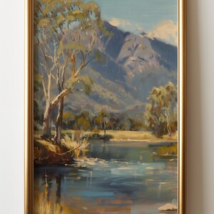 May include: A framed painting of a landscape scene with a lake, trees, and mountains in the background. The lake is a light blue color and the mountains are a dark blue color. The trees are a light green color and the sky is a light blue color.