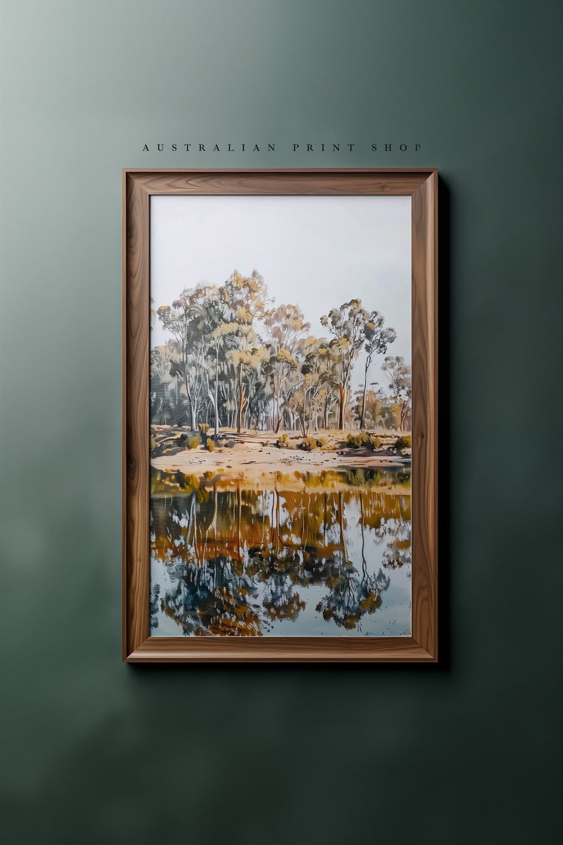 May include: A framed print of a painting depicting a reflection of trees in a still body of water. The trees are a mix of green and brown, and the water is a light blue with hints of yellow and orange.