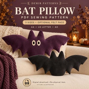 May include: A digital PDF sewing pattern for a bat-shaped pillow, titled DEMIR PATTERNS BAT PILLOW. The image displays two bat pillows, one purple with cream-coloured eyes and one black, with text indicating 3 sizes, A4, US Letter, and A0 formats.