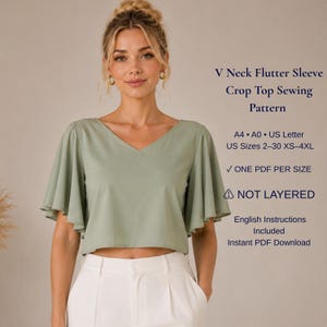 May include: A sage green V-neck crop top with flutter sleeves. Text reads: V Neck Flutter Sleeve Crop Top Sewing Pattern, A4, A0, US Letter, US Sizes 2-30 XS-4XL, ONE PDF PER SIZE, NOT LAYERED, English Instructions Included, Instant PDF Download.