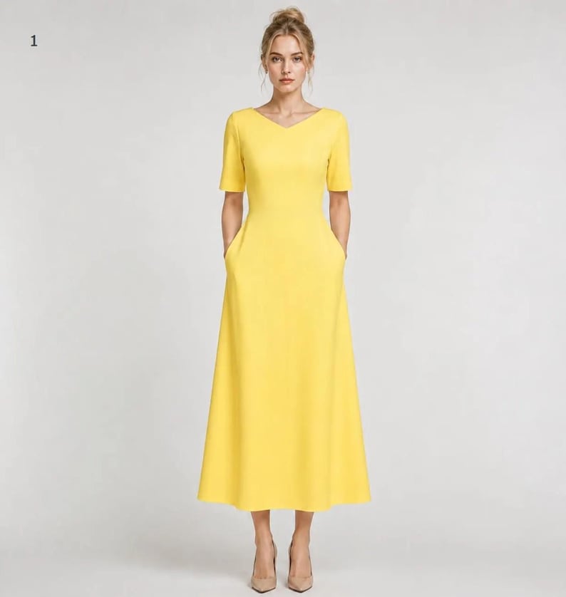 May include: A bright yellow midi dress featuring a V-neckline, short sleeves, and a fitted bodice that transitions into a flared A-line skirt. The dress includes two side pockets integrated into the seams and falls to a mid-calf length.
